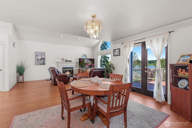 3607 Walthew Dr SE, Lacey, WA 98503 - dining space with light wood-style floors, a glass covered fireplace, french doors, vaulted ceiling, and a chandelier