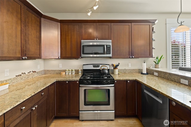 616 Glen St Unit 101, Edmonds, WA 98020 - kitchen featuring appliances with stainless steel finishes, light wood-type flooring, light stone countertops, open shelves, and hanging light fixtures