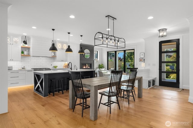 3705 N 18th St, Tacoma, WA 98406 - dining room featuring light wood-style floors, recessed lighting, a glass covered fireplace, crown molding, and a chandelier