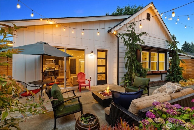 3705 N 18th St, Tacoma, WA 98406 - rear view of house with board and batten siding, a patio, and an outdoor living space with a fire pit