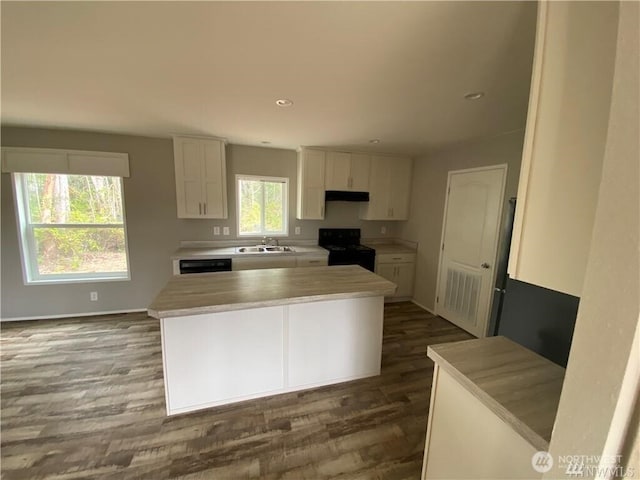 911 Mill Crk, Shelton, WA 98584 - kitchen with black range with electric stovetop, dark wood-style flooring, white cabinetry, under cabinet range hood, and recessed lighting