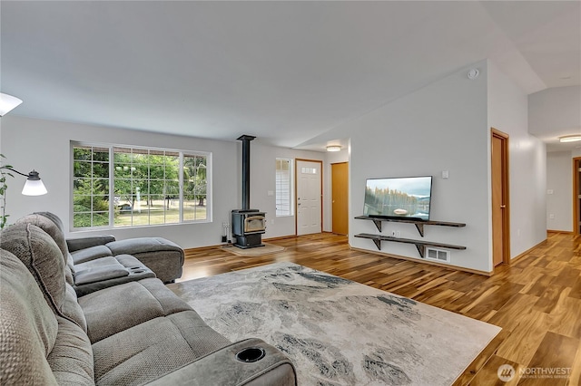 9540 El Camino Ln SE, Yelm, WA 98597 - living room featuring lofted ceiling, wood finished floors, and a wood stove