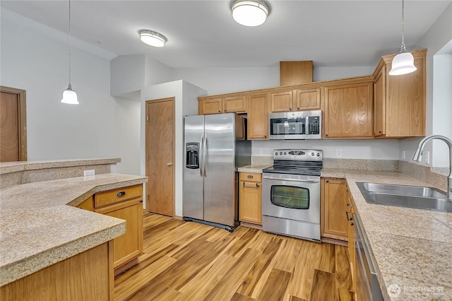 9540 El Camino Ln SE, Yelm, WA 98597 - kitchen with stainless steel appliances, lofted ceiling, light wood-style floors, hanging light fixtures, and tile counters