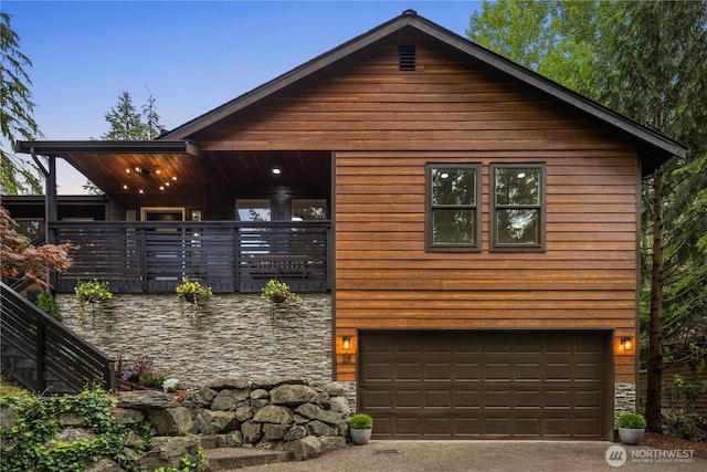 28 Lost Lake Ln, Bellingham, WA 98229 - rustic home with stone siding, an attached garage, a porch, and concrete driveway