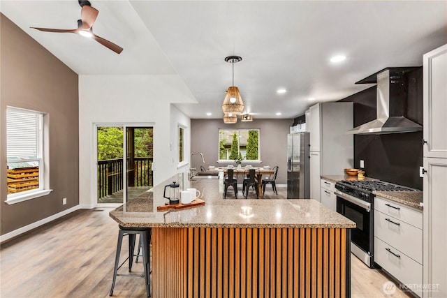 28 Lost Lake Ln, Bellingham, WA 98229 - kitchen featuring wall chimney exhaust hood, gas range oven, stainless steel fridge with ice dispenser, light wood finished floors, and recessed lighting