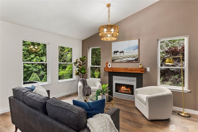 28 Lost Lake Ln, Bellingham, WA 98229 - living area featuring vaulted ceiling, a lit fireplace, wood finished floors, and a chandelier