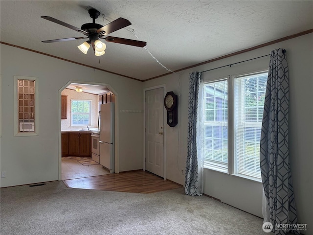 7519 18th Avenue Ct E, Tacoma, WA 98404 - foyer entrance featuring crown molding, arched walkways, light colored carpet, a ceiling fan, and a textured ceiling