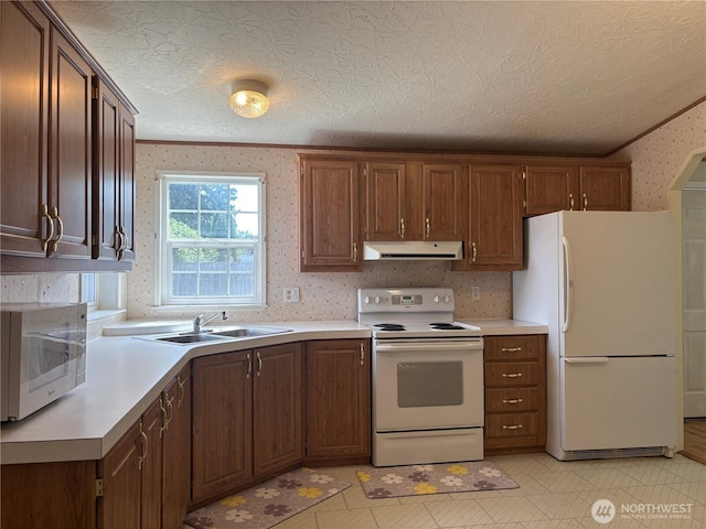 7519 18th Avenue Ct E, Tacoma, WA 98404 - kitchen with white appliances, under cabinet range hood, wallpapered walls, light countertops, and crown molding