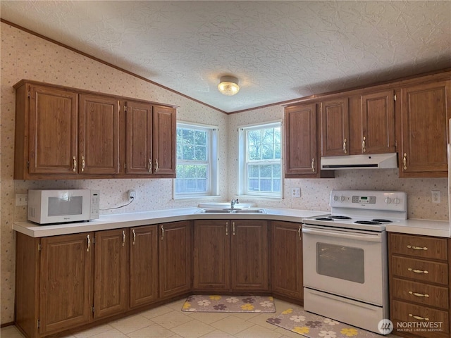 7519 18th Avenue Ct E, Tacoma, WA 98404 - kitchen with white appliances, under cabinet range hood, crown molding, wallpapered walls, and vaulted ceiling