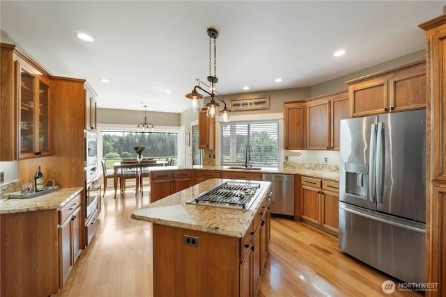 29919 39th Ave S, Roy, WA 98580 - kitchen with stainless steel appliances, brown cabinetry, light wood-style flooring, a center island, and recessed lighting