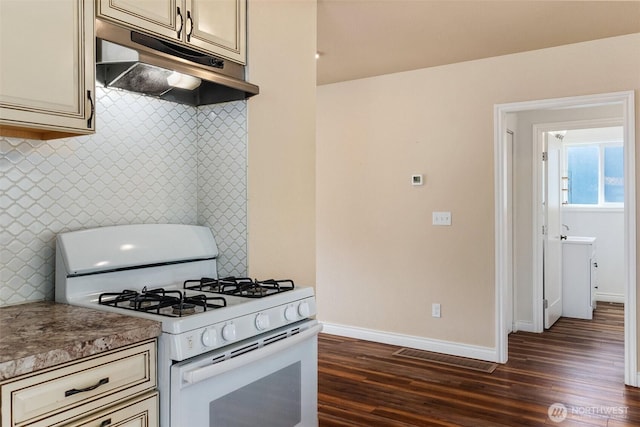212 Euclid Ave, Shelton, WA 98584 - kitchen with white range with gas stovetop, under cabinet range hood, dark wood-style flooring, and cream cabinets