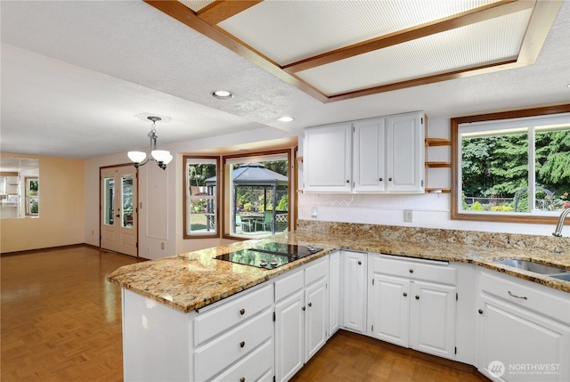 6425 Miner Dr SW, Tumwater, WA 98512 - kitchen with black electric cooktop, a peninsula, light stone counters, white cabinets, and recessed lighting