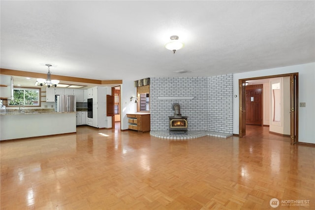 6425 Miner Dr SW, Tumwater, WA 98512 - unfurnished living room with a chandelier and a wood stove