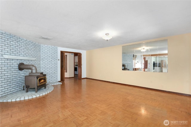 6425 Miner Dr SW, Tumwater, WA 98512 - unfurnished living room with a wood stove and brick wall