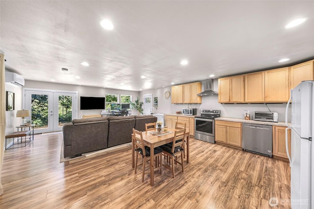 2927 Youngs Rd, Custer, WA 98240 - kitchen with appliances with stainless steel finishes, wall chimney exhaust hood, light brown cabinetry, a wall mounted air conditioner, and recessed lighting