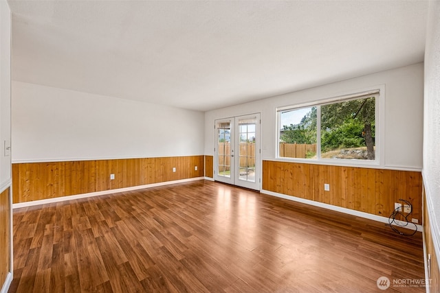 12411 134th St E, Puyallup, WA 98374 - unfurnished room featuring wood finished floors, wood walls, and a wainscoted wall