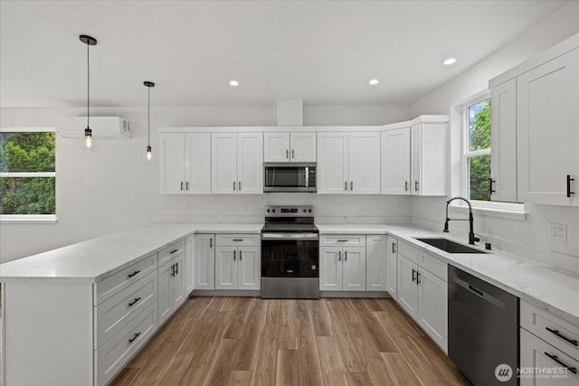 4955 Henley St, Blaine, WA 98230 - kitchen with appliances with stainless steel finishes, a peninsula, light stone countertops, light wood-type flooring, and recessed lighting