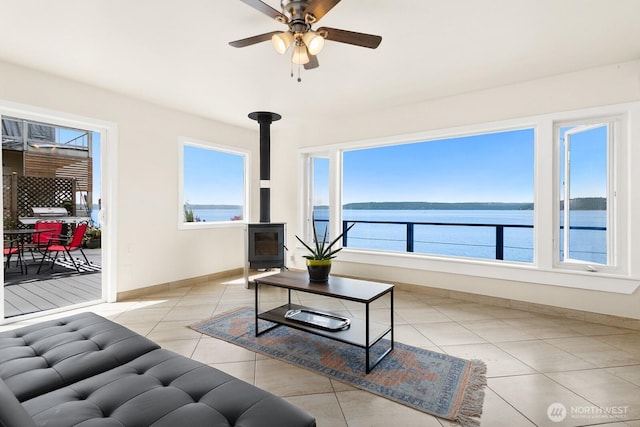 6522 Whitman St NE, Tacoma, WA 98422 - living room featuring a wood stove, light tile patterned floors, ceiling fan, and a water view