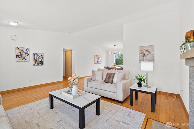 15120 61st St E, Sumner, WA 98390 - living room with vaulted ceiling, light wood-type flooring, a fireplace, and a chandelier