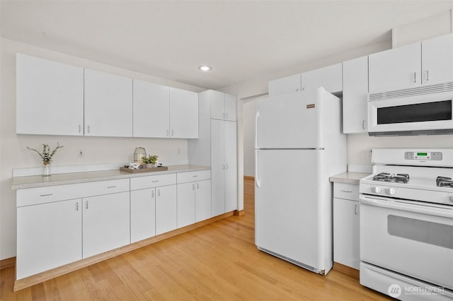 15120 61st St E, Sumner, WA 98390 - kitchen with white appliances, light wood-type flooring, recessed lighting, light countertops, and white cabinetry