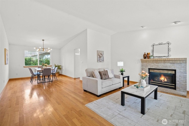 15120 61st St E, Sumner, WA 98390 - living area with light wood-type flooring, a brick fireplace, lofted ceiling, and a chandelier