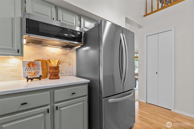 1802 Zephyr Ln NW, Silverdale, WA 98383 - kitchen with stainless steel appliances, decorative backsplash, light countertops, light wood-style flooring, and gray cabinetry