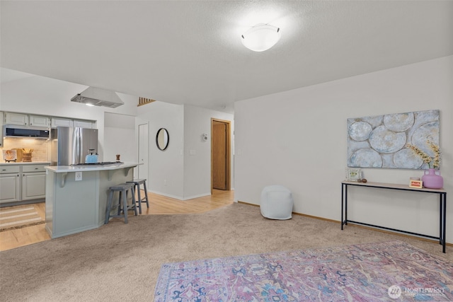1802 Zephyr Ln NW, Silverdale, WA 98383 - kitchen with appliances with stainless steel finishes, light carpet, a breakfast bar area, gray cabinetry, and a kitchen island