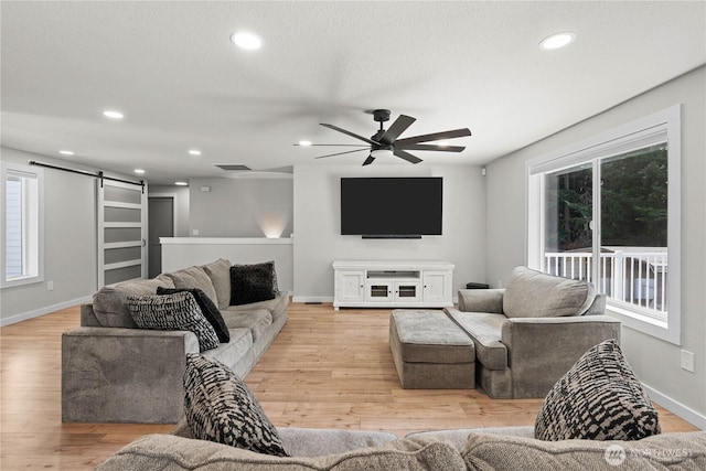 8209 188th Ave E, Bonney Lake, WA 98391 - living area with a barn door, light wood-style flooring, ceiling fan, and recessed lighting