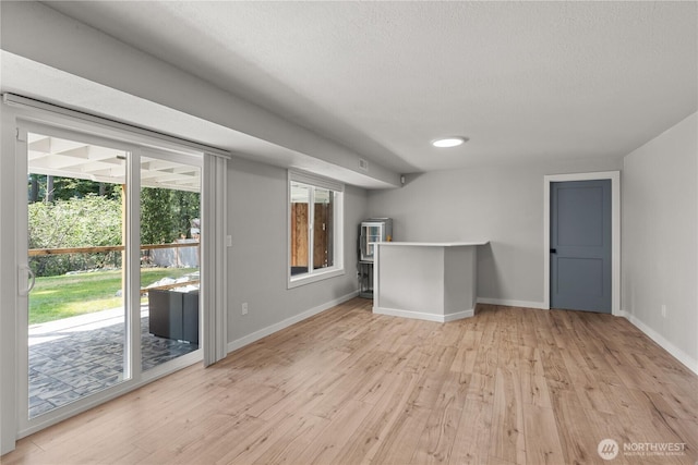 8209 188th Ave E, Bonney Lake, WA 98391 - unfurnished living room with light wood finished floors and a textured ceiling