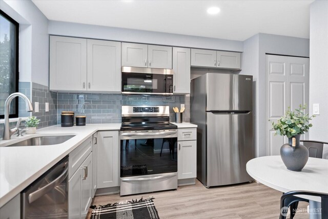 506 102nd Dr SE, Lake Stevens, WA 98258 - kitchen with stainless steel appliances, light countertops, decorative backsplash, light wood-type flooring, and recessed lighting