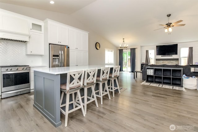 4706 56th St E, Tacoma, WA 98443 - kitchen featuring stainless steel appliances, lofted ceiling, white cabinets, light countertops, and a kitchen island