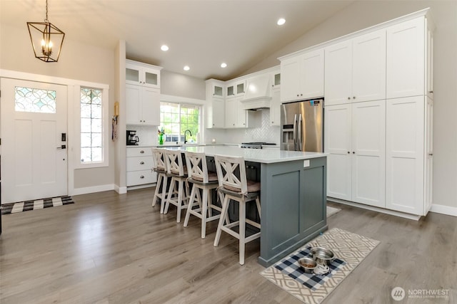 4706 56th St E, Tacoma, WA 98443 - kitchen featuring stainless steel refrigerator with ice dispenser, a kitchen island, light countertops, backsplash, and white cabinets