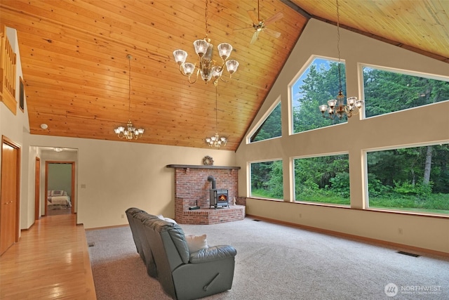1931B State Route 505, Toledo, WA 98591 - living area with a chandelier, high vaulted ceiling, wooden ceiling, a wood stove, and carpet