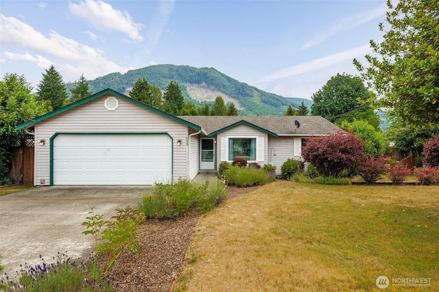 650 Elwell Ave, Darrington, WA 98241 - view of front of property with a mountain view, concrete driveway, a garage, and a front lawn