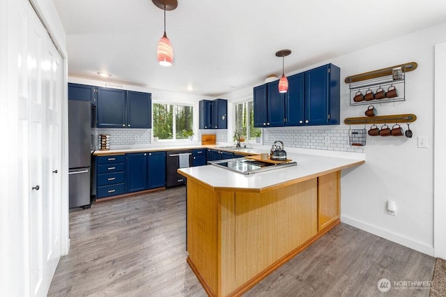 43920 SE 170th St, North Bend, WA 98045 - kitchen with blue cabinets, dishwashing machine, cooktop, a peninsula, and freestanding refrigerator