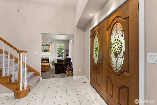 30630 24th Ave S, Roy, WA 98580 - foyer entrance featuring light colored carpet, stairs, a warm lit fireplace, and light tile patterned floors