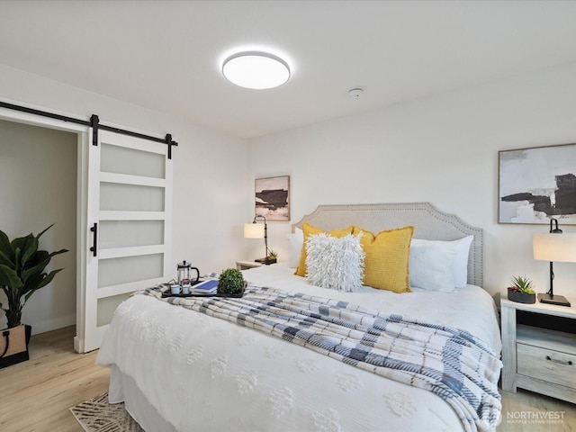 3704 Bells Ln, Langley, WA 98260 - bedroom featuring a barn door and wood finished floors