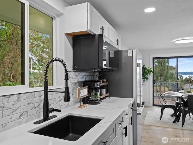 3704 Bells Ln, Langley, WA 98260 - kitchen featuring backsplash, light stone counters, white cabinetry, recessed lighting, and light wood-style flooring