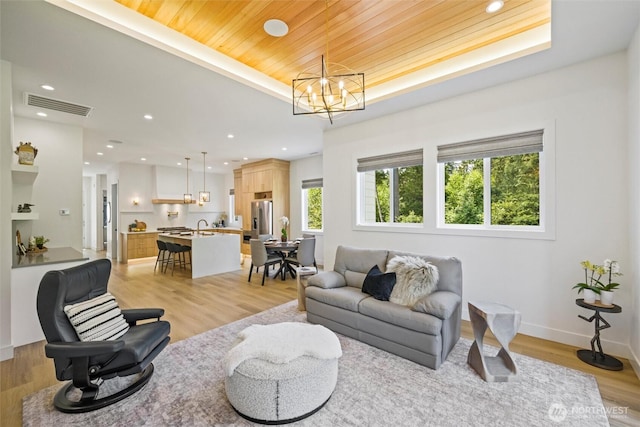 9051 Sea Mist Ln, Blaine, WA 98230 - living room featuring a chandelier, light wood-type flooring, wooden ceiling, recessed lighting, and a raised ceiling