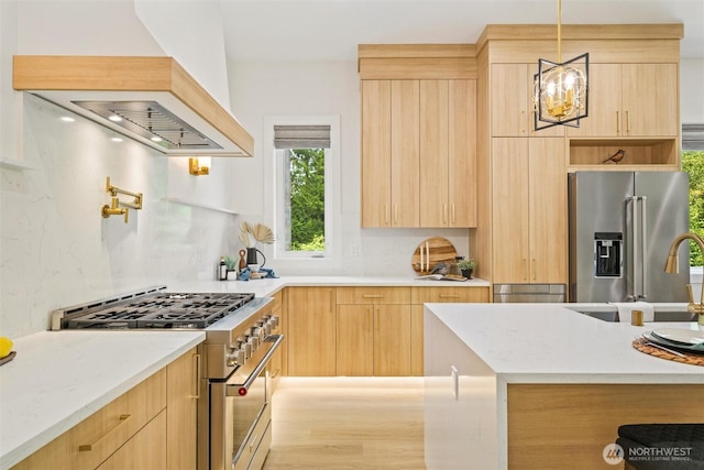 9051 Sea Mist Ln, Blaine, WA 98230 - kitchen featuring high end appliances, light brown cabinetry, custom exhaust hood, modern cabinets, and decorative light fixtures