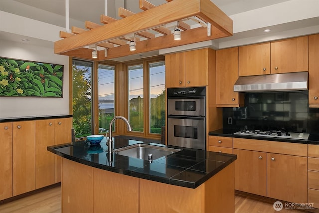 2337 NW 194th Pl, Shoreline, WA 98177 - kitchen with under cabinet range hood, stainless steel double oven, white gas cooktop, light wood finished floors, and recessed lighting