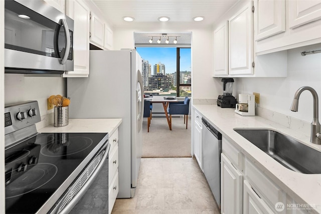 2201 3rd Ave Unit 1404, Seattle, WA 98121 - kitchen with appliances with stainless steel finishes, white cabinetry, light stone countertops, recessed lighting, and a view of city