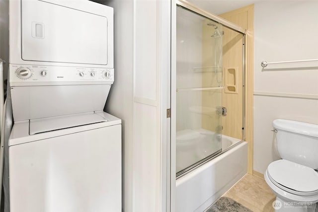 2201 3rd Ave Unit 1404, Seattle, WA 98121 - bathroom with stacked washer and clothes dryer, shower / bath combination with glass door, and tile patterned floors