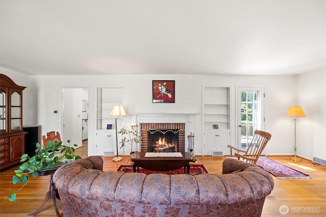 444 Washington St, Walla Walla, WA 99362 - living room featuring built in shelves, a brick fireplace, and wood finished floors