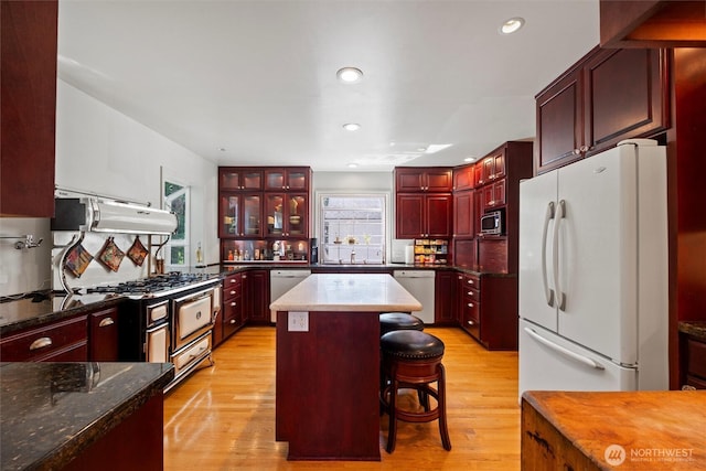 444 Washington St, Walla Walla, WA 99362 - kitchen with dark brown cabinets, white appliances, range hood, light wood-style flooring, and a kitchen island