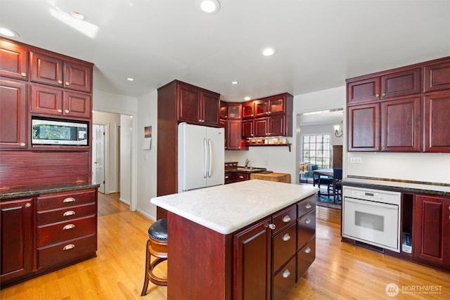 444 Washington St, Walla Walla, WA 99362 - kitchen with dark brown cabinets, white appliances, light wood finished floors, a center island, and recessed lighting