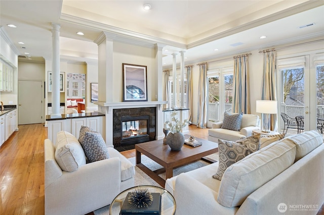 1510 38th Ave E, Seattle, WA 98112 - living room featuring decorative columns, light wood-type flooring, crown molding, a tile fireplace, and recessed lighting
