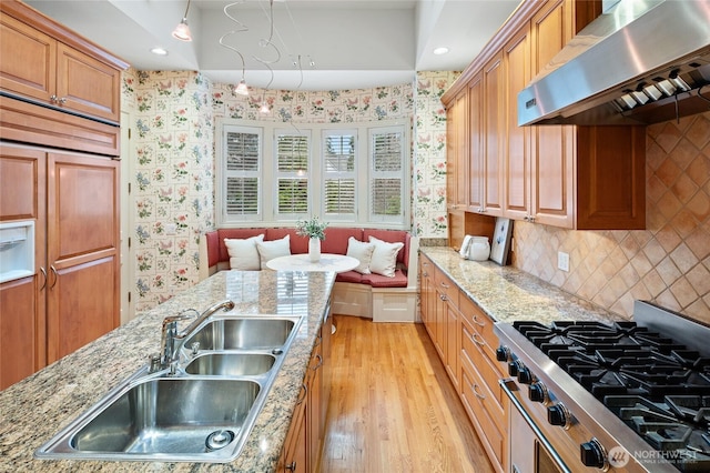 1510 38th Ave E, Seattle, WA 98112 - kitchen with exhaust hood, cooktop, wallpapered walls, light wood-style flooring, and light stone countertops