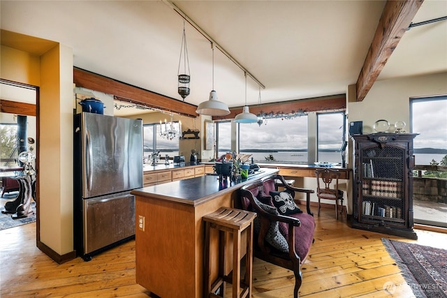 4722 53rd Ave SW, Seattle, WA 98116 - kitchen with freestanding refrigerator, light wood finished floors, beam ceiling, and plenty of natural light