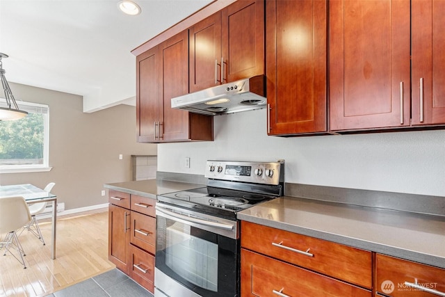 3017 Government Way, Seattle, WA 98199 - kitchen with stainless steel electric range, under cabinet range hood, brown cabinetry, and recessed lighting